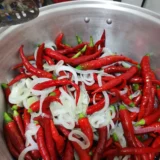 Chiles rojos y cebolla en una olla de cocina tradicional